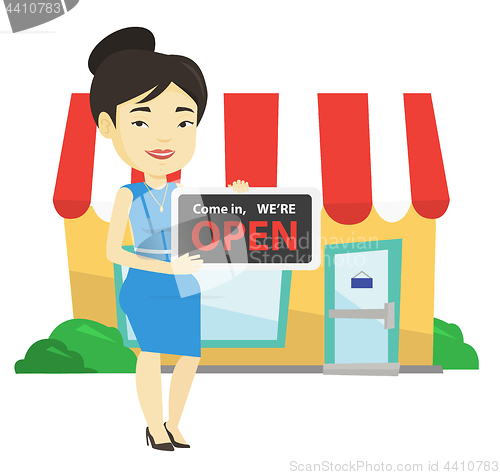 Image of Female shop owner holding open signboard.