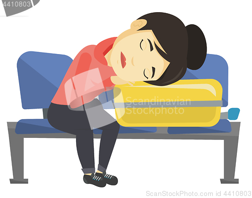 Image of Exhausted woman sleeping on suitcase at airport.