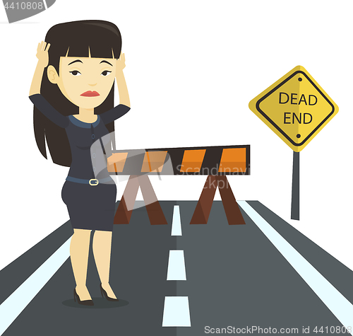 Image of Business woman looking at road sign dead end.