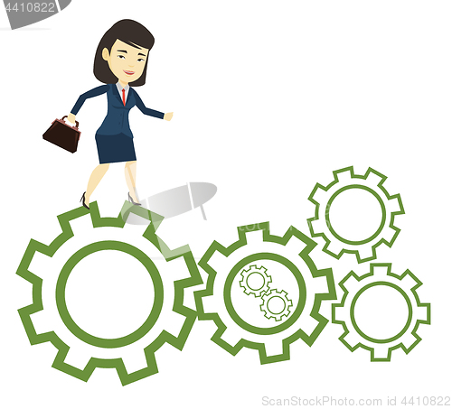 Image of Business woman running on cogwheels.