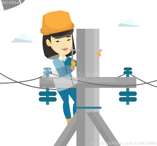 Image of Electrician working on electric power pole.