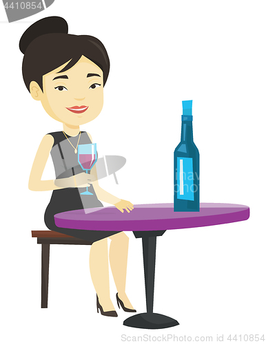 Image of Woman drinking wine at restaurant.