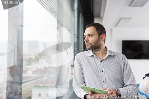 Image of Businessman Using Tablet In Office Building by window