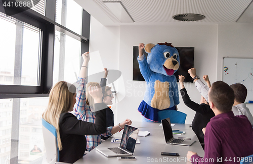 Image of boss dresed as bear having fun with business people in trendy of