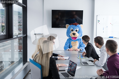 Image of boss dresed as bear having fun with business people in trendy of