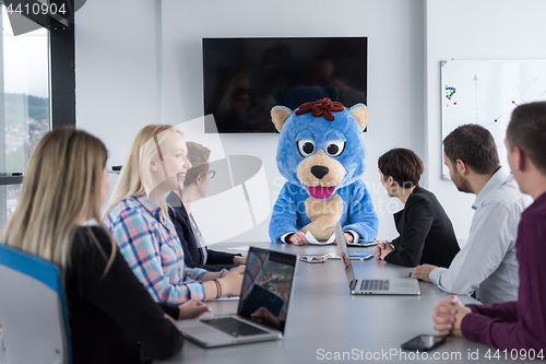 Image of boss dresed as bear having fun with business people in trendy of