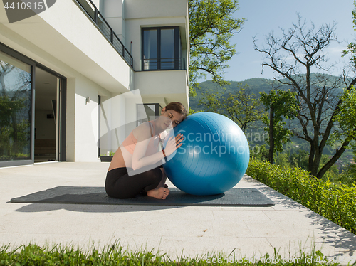 Image of woman doing exercise with pilates ball