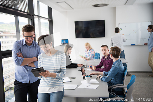 Image of Two Business People Working With Tablet in office