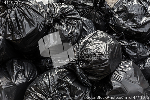 Image of Pile of black waste plastic bin bag background.