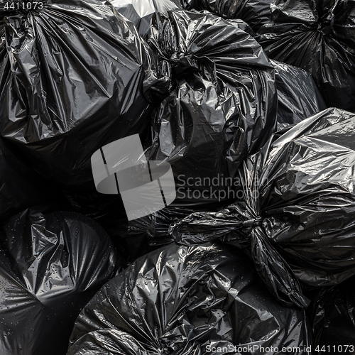 Image of Pile of black waste plastic bin bag background.