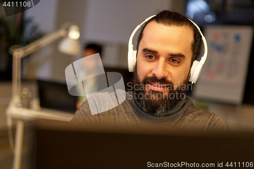 Image of creative man with headphones working at office