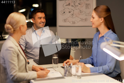 Image of business team with laptop working at night office