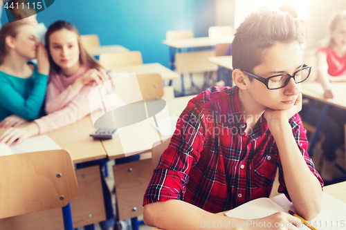 Image of students gossiping behind classmate back at school