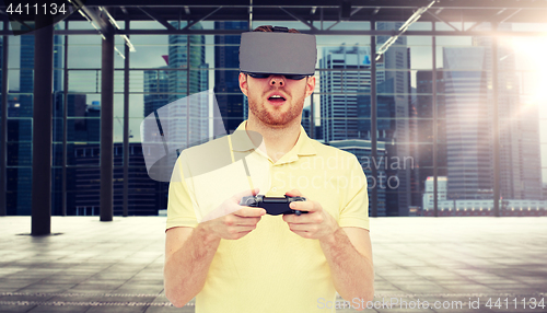 Image of man in virtual reality headset with gamepad