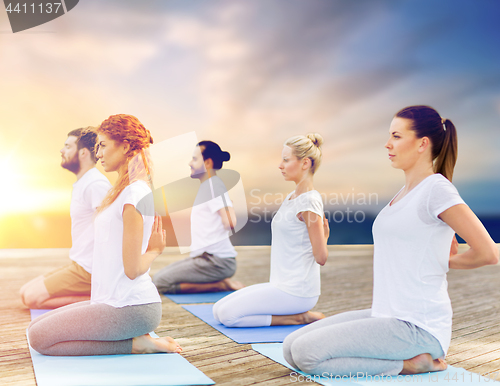 Image of group of people doing yoga outdoors