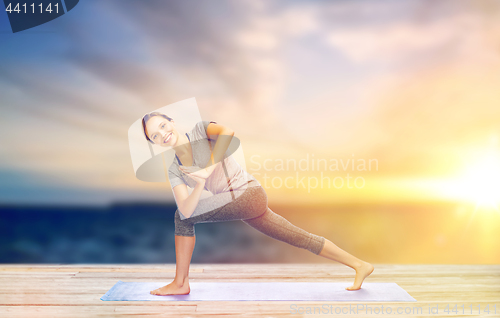 Image of woman making yoga low angle lunge pose on mat