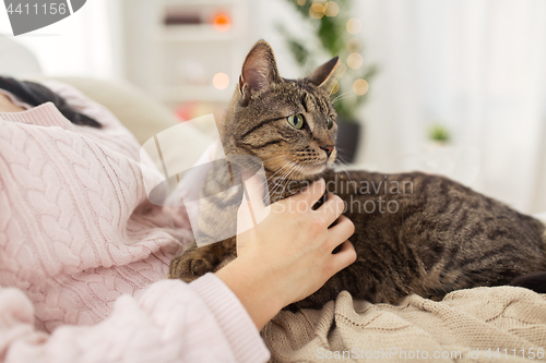 Image of close up of owner with tabby cat in bed at home