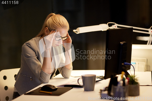 Image of businesswoman at computer working at night office