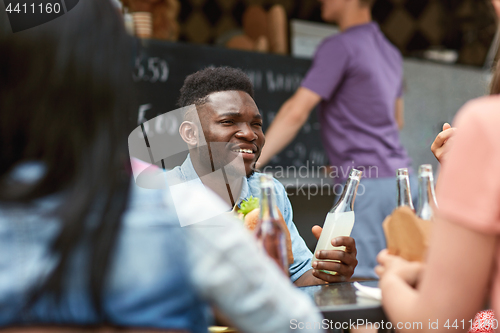 Image of friends with drinks sitting at table at food truck