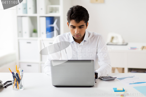 Image of businessman with laptop working at office