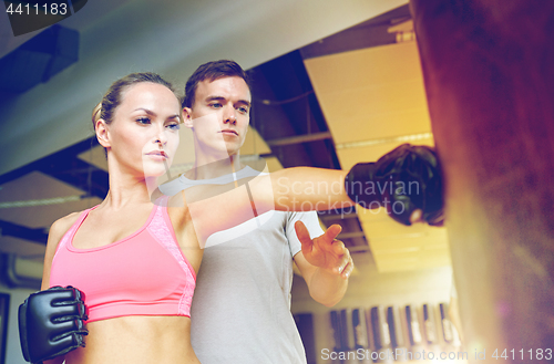 Image of woman with personal trainer boxing in gym