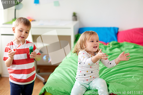 Image of kids blowing soap bubbles and playing at home