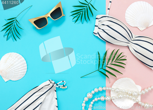 Image of Tropical vacation flat lay on blue and pink background