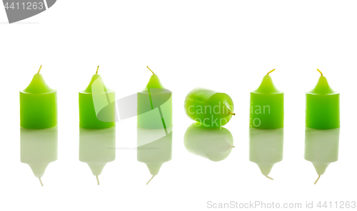 Image of Row of green candles, with one laying down