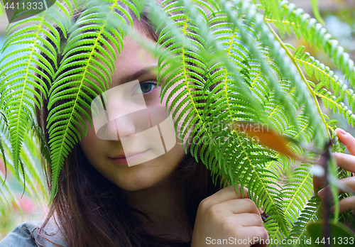 Image of Teen girl watching through leaves