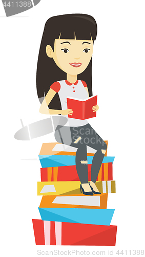 Image of Student sitting on huge pile of books.