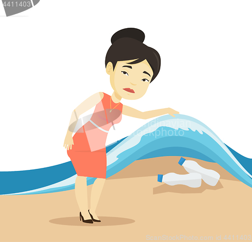 Image of Woman showing plastic bottles under sea wave.