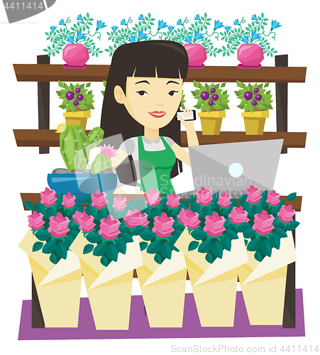 Image of Owner of flower shop talking on a phone.