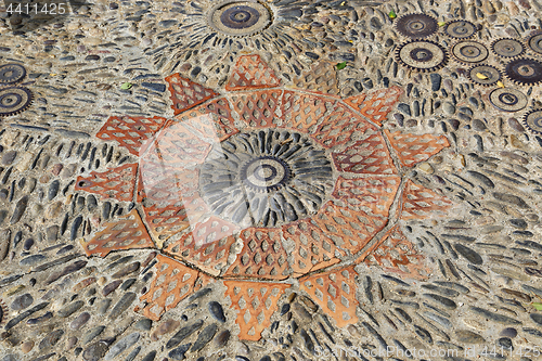 Image of Patterned floor with pattern from pebbles bricks and gears