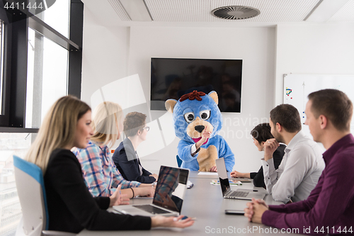 Image of boss dresed as bear having fun with business people in trendy of