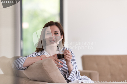 Image of young woman in a bathrobe enjoying morning coffee