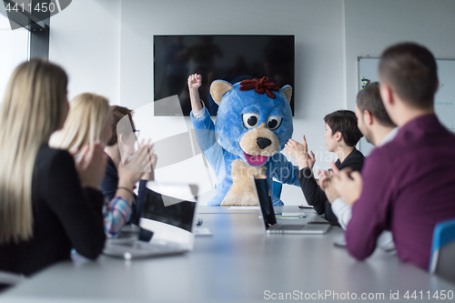 Image of boss dresed as bear having fun with business people in trendy of