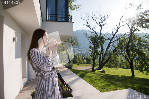 Image of woman in a bathrobe enjoying morning coffee