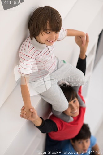 Image of young boys posing line up piggyback top view