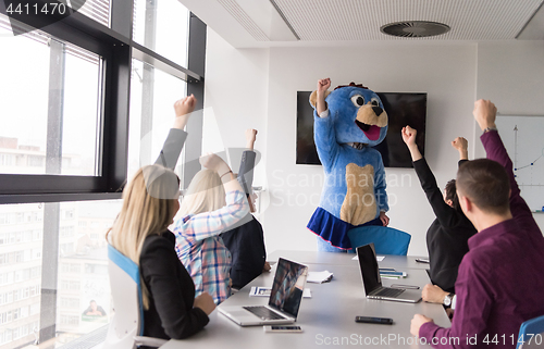 Image of boss dresed as bear having fun with business people in trendy of