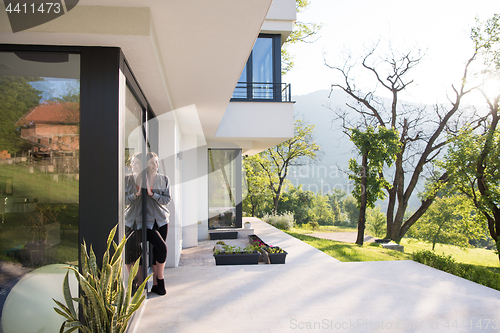 Image of woman in front of her luxury home villa