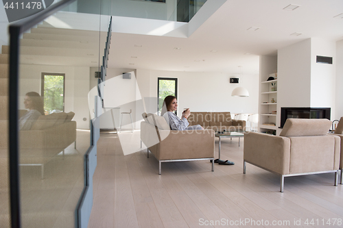 Image of young woman in a bathrobe enjoying morning coffee