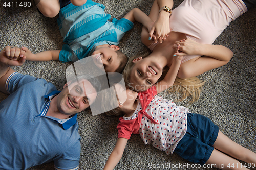 Image of happy family lying on the floor