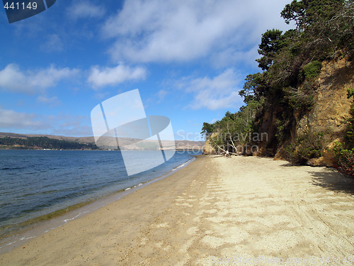 Image of deserted beach with blue sky and white clouds