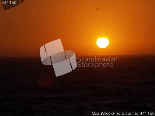 Image of dark sunset over the ocean orange and black