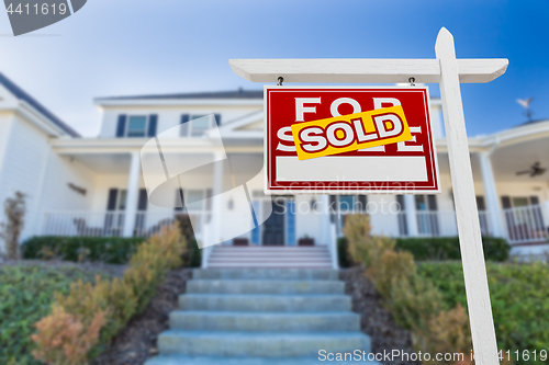 Image of Left Facing Sold For Sale Real Estate Sign In Front of House.