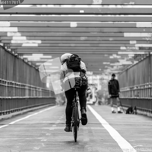 Image of Man riding his bike in the cycling lane on Williamsburg Bridge, Brooklyn, New York City.