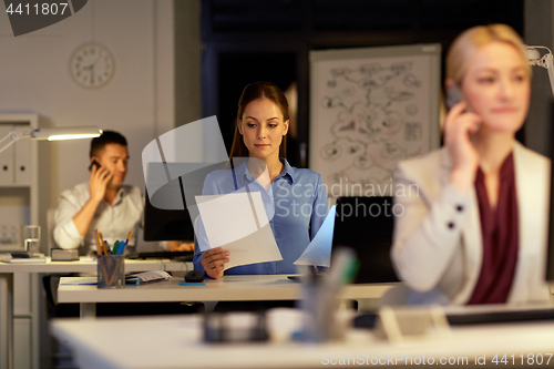 Image of businesswoman at computer working at night office