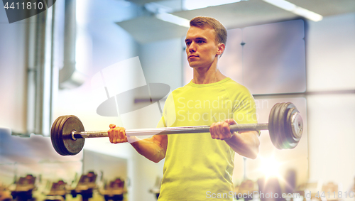 Image of man doing exercise with barbell in gym