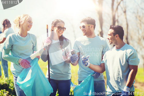 Image of volunteers with garbage bags cleaning park area