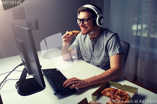 Image of man in headset playing computer video game at home